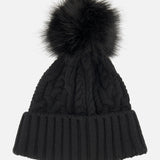The Cableknit Pom Beanie by MONCLER is a black knit beanie featuring a large, fluffy faux fur pom-pom on top and a wide, ribbed fold-over brim, exuding the cozy style characteristic of classic Moncler beanies. Shown here against a plain white background.