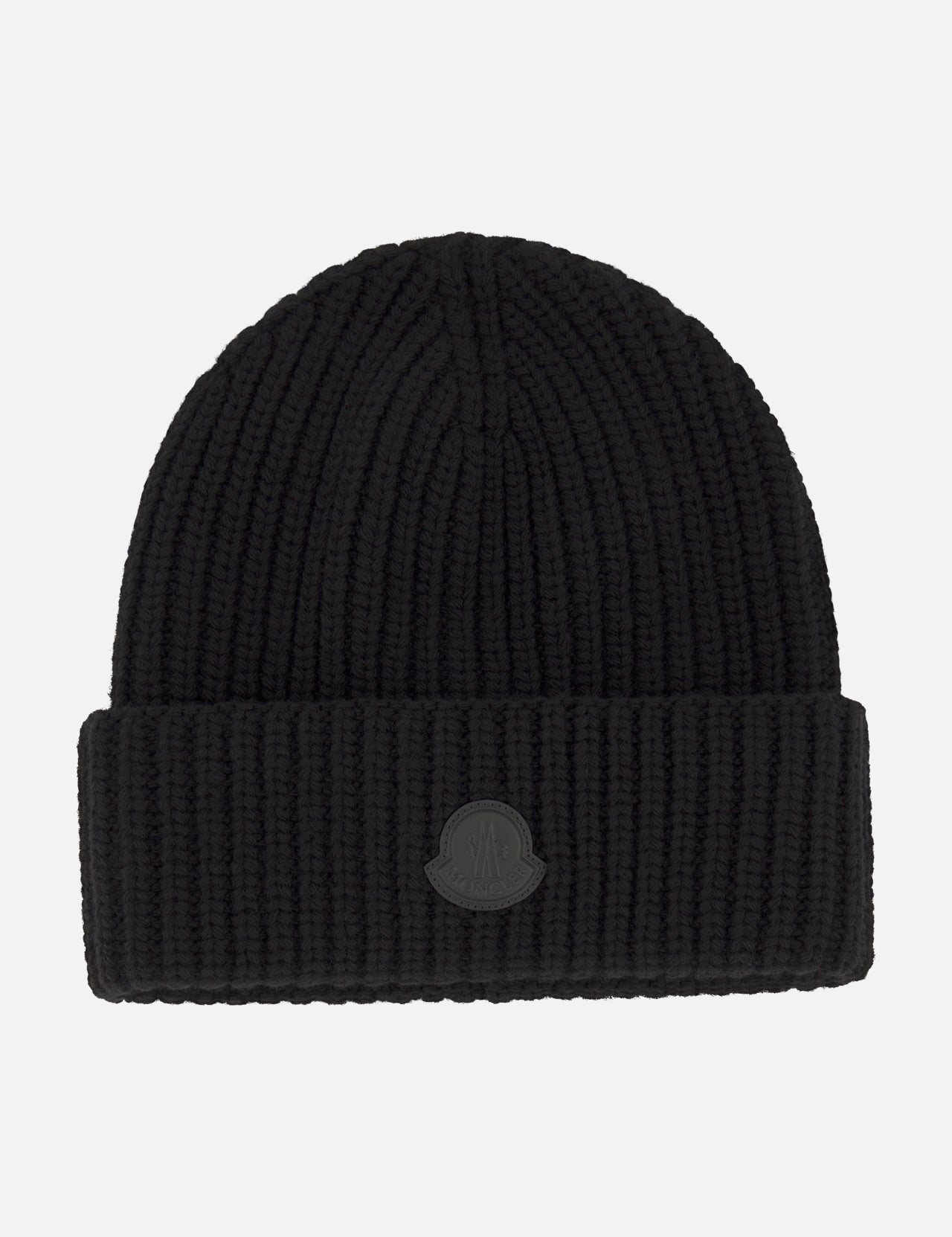 A black Tonal Logo Beanie by MONCLER, crafted from luxurious virgin wool cashmere with a wide folded cuff and a round tonal embossed logo patch on the front, photographed against a plain white background.