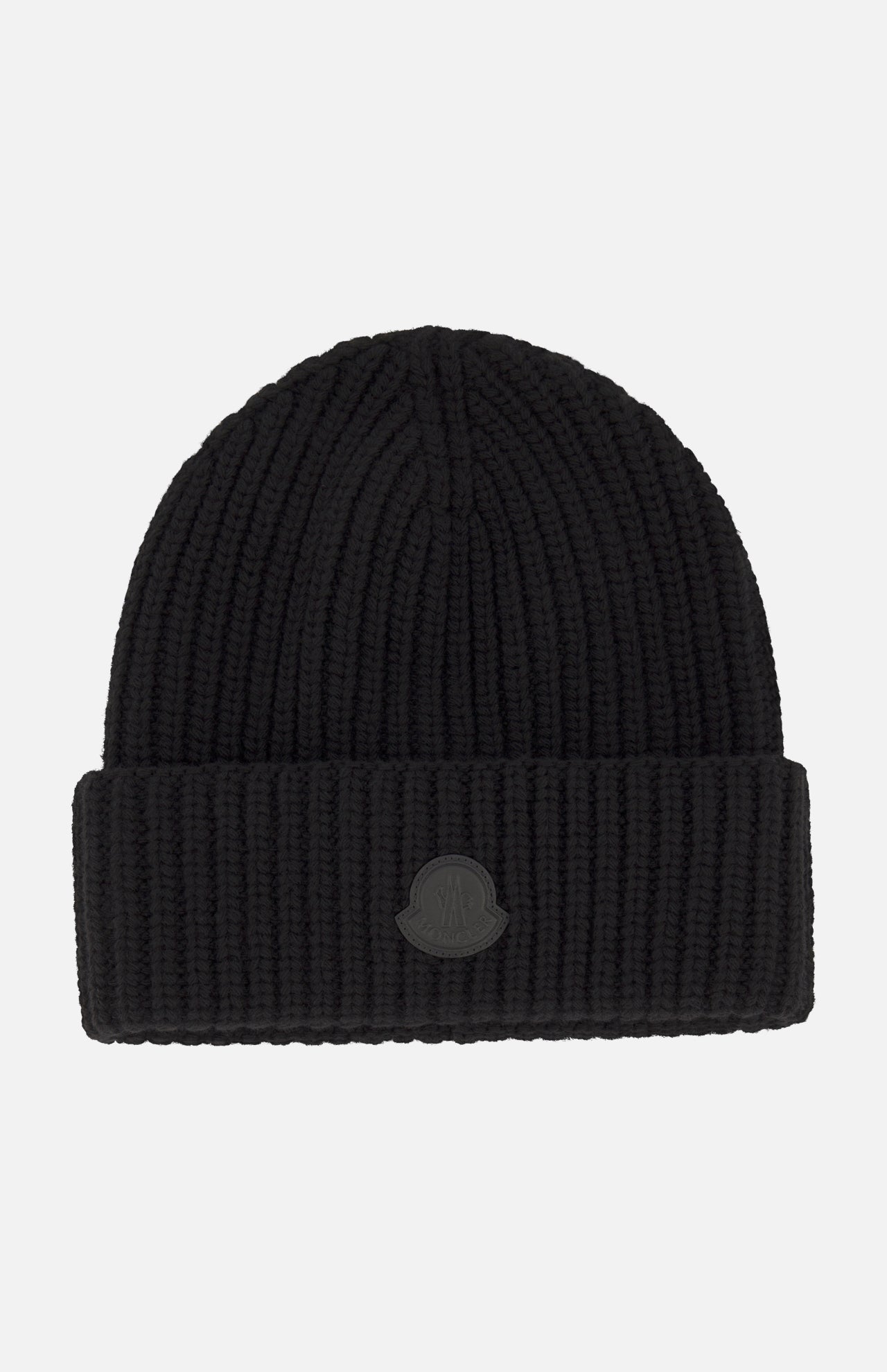 A black Tonal Logo Beanie by MONCLER, crafted from luxurious virgin wool cashmere with a wide folded cuff and a round tonal embossed logo patch on the front, photographed against a plain white background.