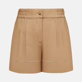 The MONCLER Brushed Techno Cotton Shorts feature beige tailoring, front pleats, an elasticated waistband with belt loops, button and zip closure, and a subtle horizontal seam for refined style in high-performance wear.