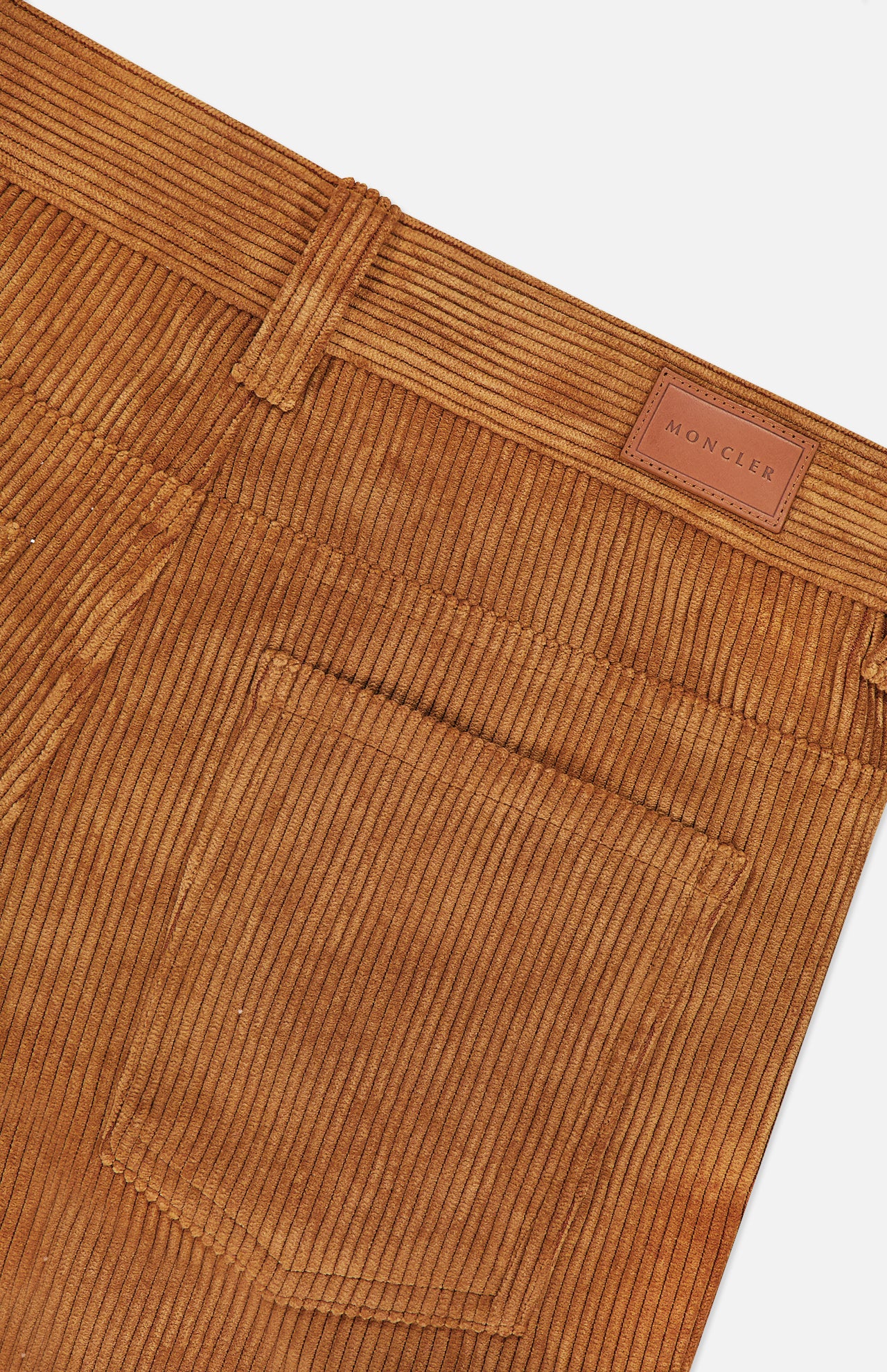 Close-up of MONCLER Corduroy 5-Pocket Trousers, featuring the back pocket, belt loops, and a brown leather MONCLER patch above the pocket.
