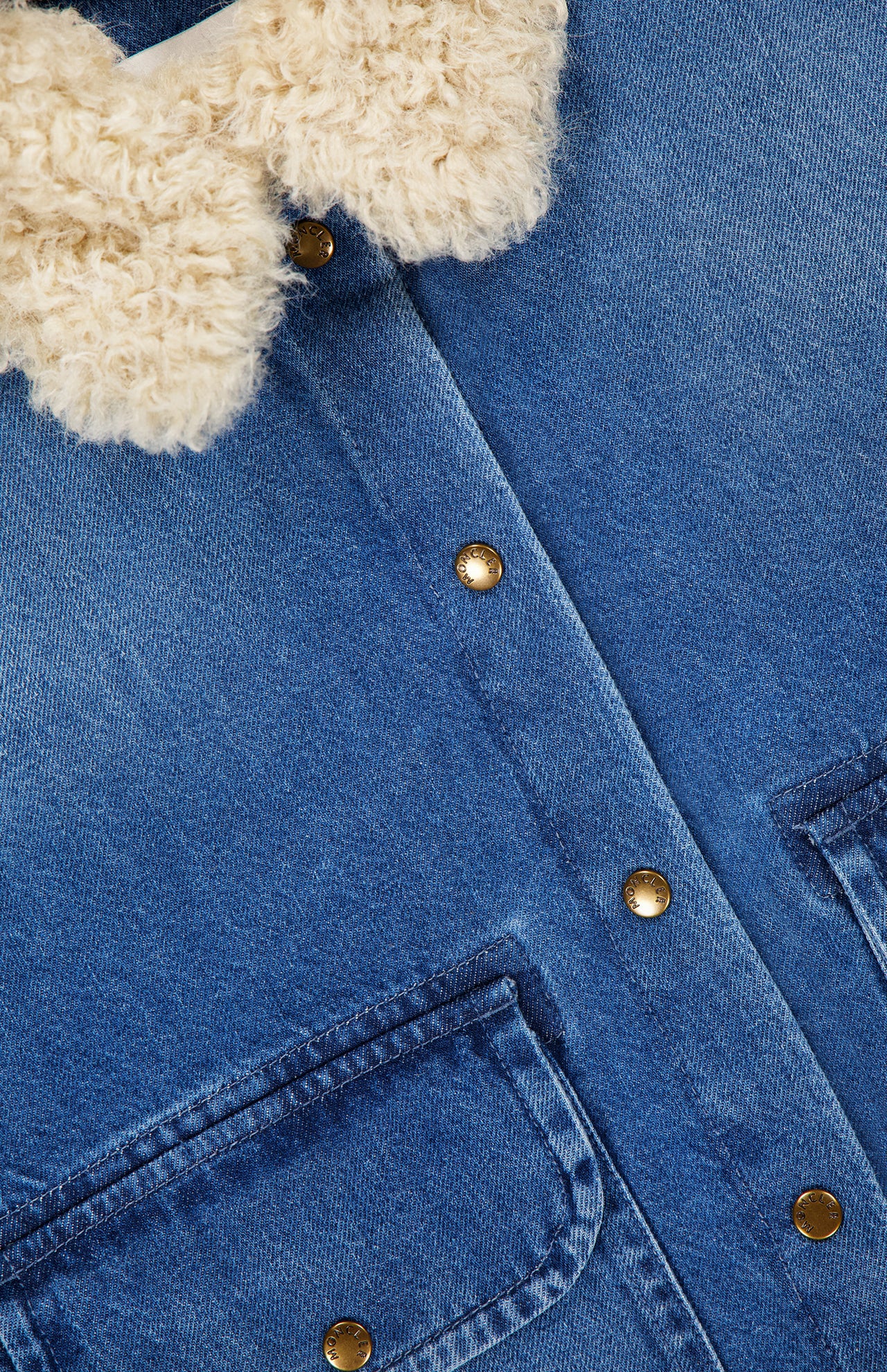 Close-up of the MONCLER Denim Vintage Jacket with Removable Collar, featuring gold snap buttons, two front pockets, and a fluffy cream sherpa collar for a stylish blend of modern and vintage outerwear appeal.