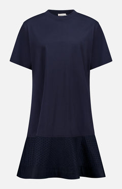 The MONCLER Embroidered Hem Mini Dress is a navy, short-sleeve cotton mini with a round neckline, relaxed fit, flared hem, and subtle embroidery near the bottom for chic summer style. No visible fastenings or embellishments.