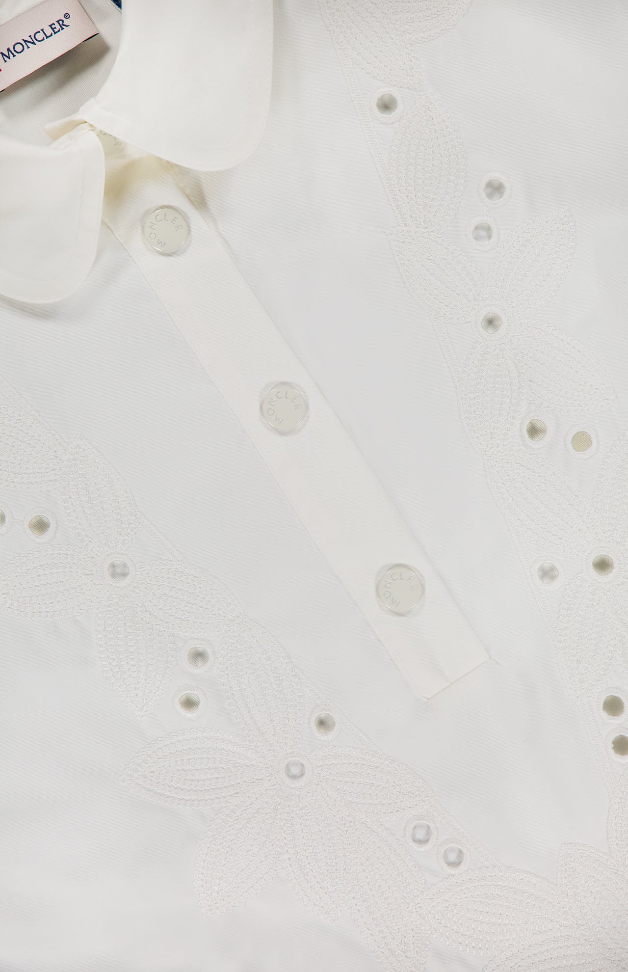 Close-up of the MONCLER Embroidered Mini Dress, showcasing a large collar, decorative floral embroidery, and embossed white buttons.