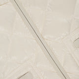 Close-up of the MONCLER Lavaret Quilted Puffer Jacket in cream, showcasing its classic quilted texture, diagonal zipper, and button-flap pocket. Lightweight design highlights signature stitching inspired by Moncler’s iconic puffer styles.