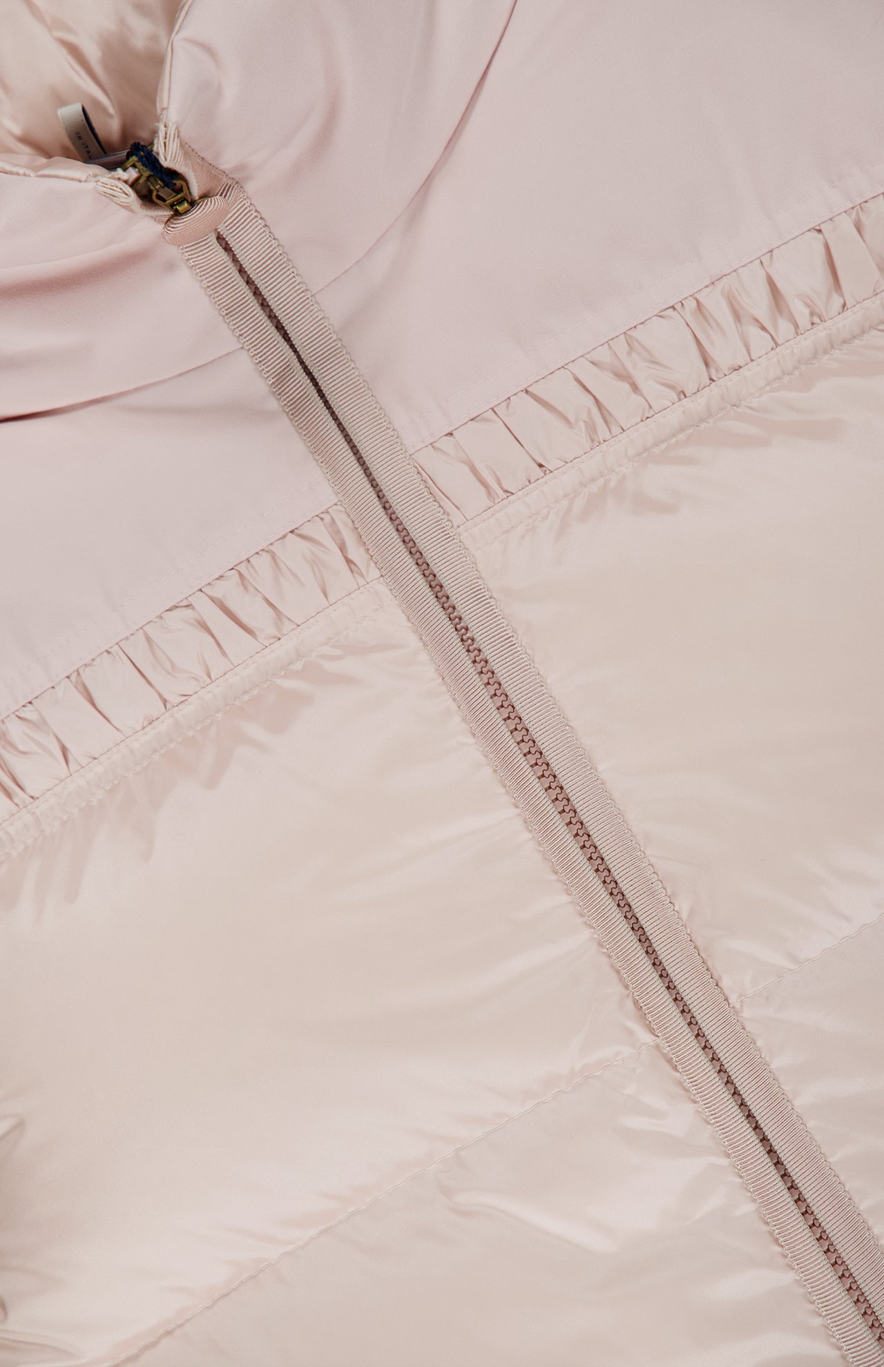 Close-up of the MONCLER Meditation Puffer Jacket in light pink, down-filled with a visible zipper and gathered stitching detail beneath the collar.
