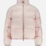 The Meditation Puffer Jacket by MONCLER is a light pink, down-filled, quilted jacket with a front zipper, high collar, elastic cuffs, and a slightly cropped fit, shown on a plain white background.