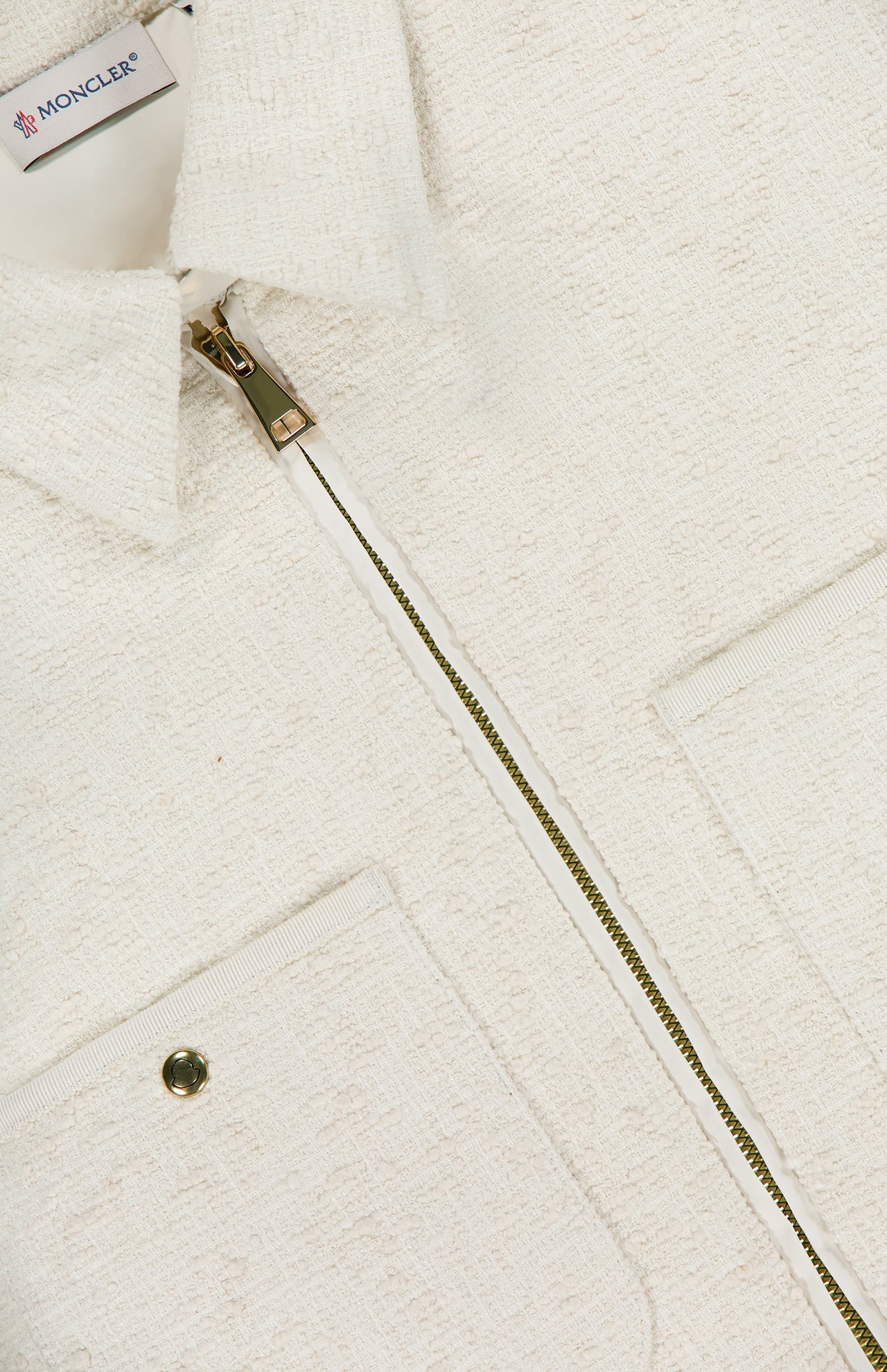 Close-up of the MONCLER Bouclé Fabric Shacket Shirt in cream cotton-blend, featuring textured bouclé, a metal zipper, collared neckline, two front pockets (one with a snap button), and the brand label inside the collar.