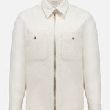 The MONCLER Bouclé Fabric Shacket Shirt in cream features long sleeves, textured cotton-blend bouclé, a classic collar, front zipper closure, and two button-flap chest pockets, shown against a plain white background.