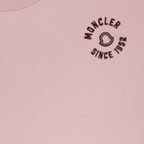 Close-up of a light pink MONCLER Short Sleeve T-Shirt, showcasing logo details and "MONCLER SINCE 1952" embroidered in black on the left chest, with a partial view of the inner collar label.