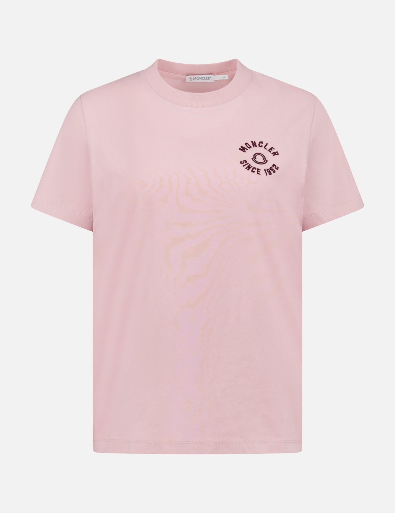 The MONCLER Short Sleeve T-Shirt features light pink fabric, a round neck, and black "MONCLER SINCE 1952" text with a small graphic on the left chest, plus signature logo detailing.