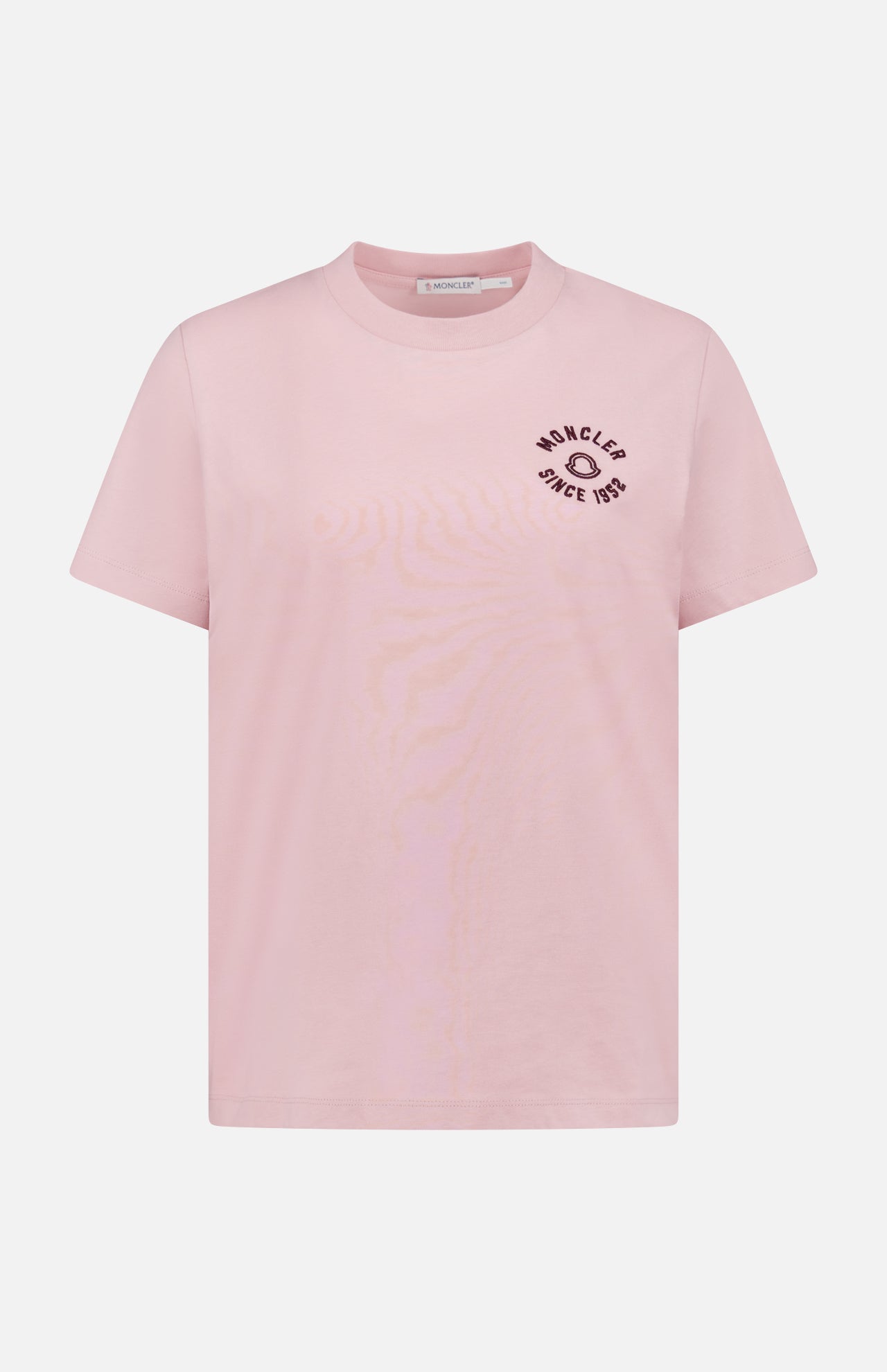 The MONCLER Short Sleeve T-Shirt features light pink fabric, a round neck, and black "MONCLER SINCE 1952" text with a small graphic on the left chest, plus signature logo detailing.