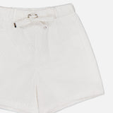 MONCLER Drawstring Eyelet Shorts in white feature an elastic waistband, drawstring tie, side pockets, and a delicate eyelet texture, showcased against a plain white background.