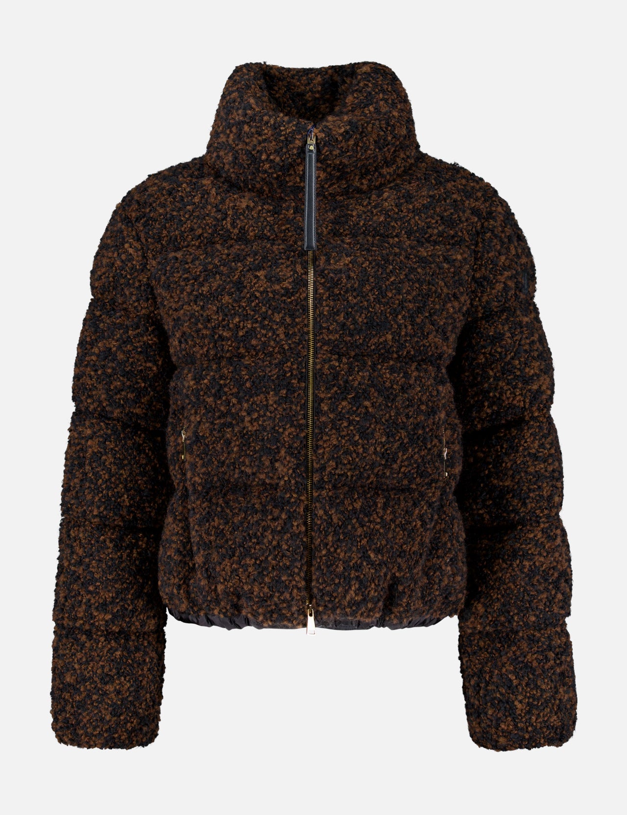 The MONCLER Trascendance Tweed Jacket is an elegant women’s outerwear piece, featuring a brown and black textured design with a high collar, front zipper, and long sleeves. Combining the warmth of a classic MONCLER down jacket with the sophisticated appeal of tweed, this jacket is displayed against a plain white background.