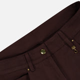 Close-up of the waistband and zipper area of MONCLER Straight Leg Trouser Pants in dark brown, featuring a brass button and zipper, visible belt loops, and pocket seams against a plain light gray background.