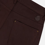 Close-up of the back pocket of MONCLER Straight Leg Trouser Pants in dark brown, featuring a small leather patch above the pocket and gold rivets on the corners.