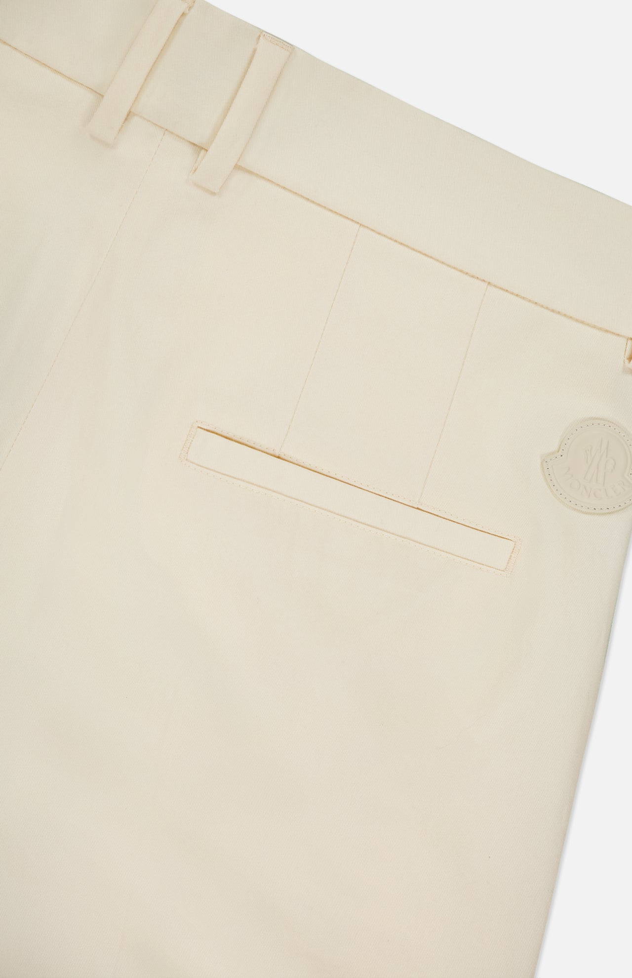 Close-up of the back of cream-colored MONCLER Wide Leg Trousers, showing a single welt pocket, belt loops, and a small circular beige logo patch near the waistband.