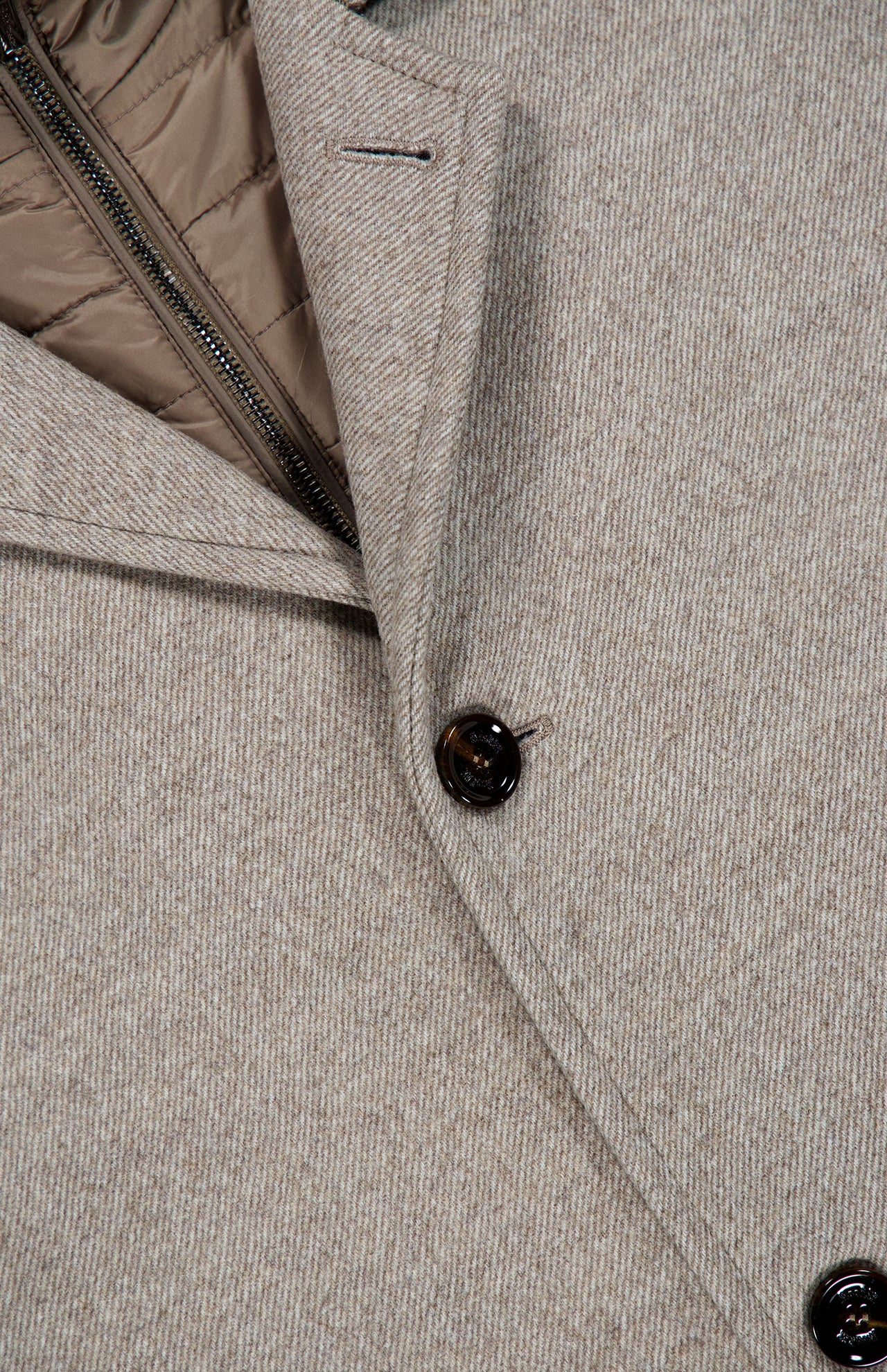 Close-up of the Monferrato Removable Bib Jacket by MOORER in light gray virgin wool, featuring a dark button, lapel, and a detachable light brown zippered interior bib.