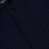 Close-up of the Reis Removable Bib Jacket by MOORER in dark navy cashmere, highlighting the textured fabric, collar, two black buttons, and part of the inner label.