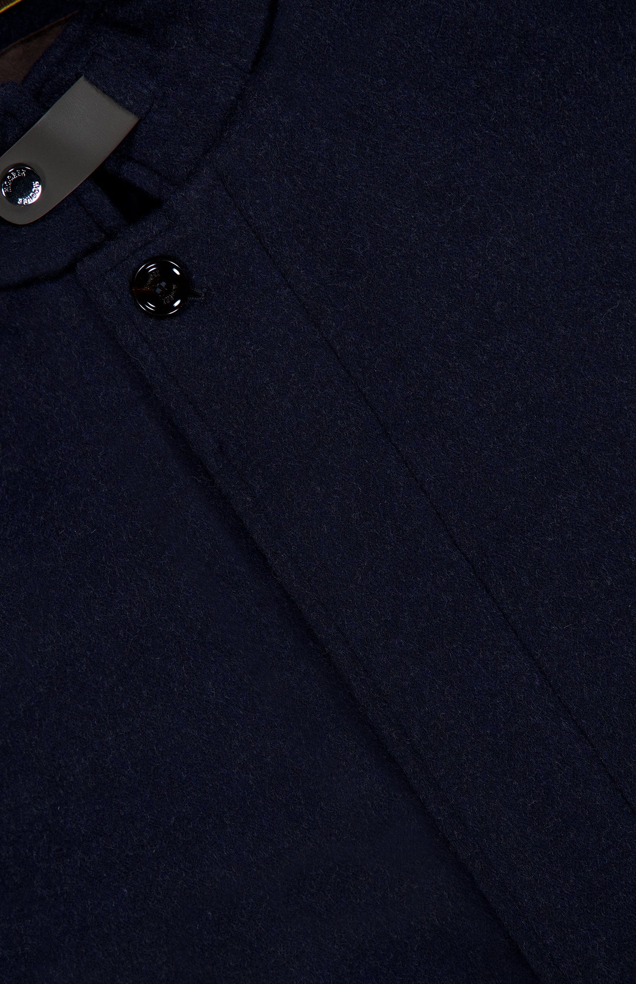 Close-up of the Reis Removable Bib Jacket by MOORER in dark navy cashmere, highlighting the textured fabric, collar, two black buttons, and part of the inner label.
