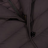 Close-up of the MOORER Sinardi Removable Bib Jacket, showing a black button, diagonal zipper, and detailed stitching on the dark brown fabric with a detachable puffer bib.