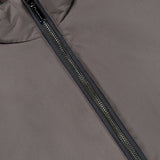 Close-up of a grey down-filled MooRER USA Traylor Vest featuring a central dark zipper and a dark brown inner collar lining.