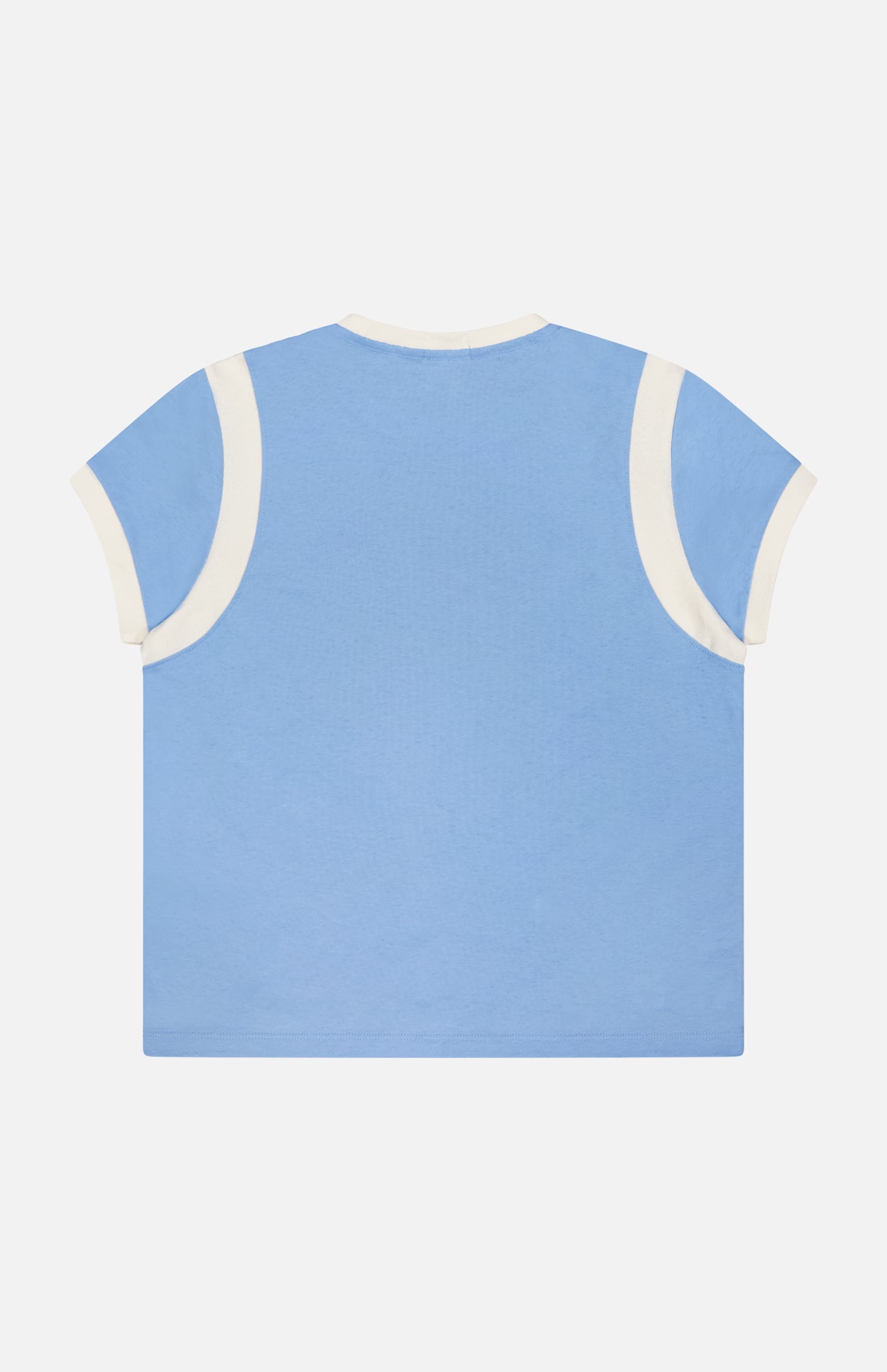 The Boxy Goodie Inset T-shirt by MOTHER, shown laid flat with its back facing up, features light blue 100% cotton fabric and white trim on the sleeves and neckline.