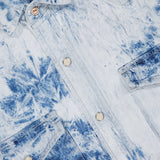 Close-up of The Exes And Ohs Overshirt by MOTHER, featuring a blue and white bleached tie-dye pattern, silver snap buttons, chest pockets, and a fabric label in the top left—showcasing its Western-inspired style.