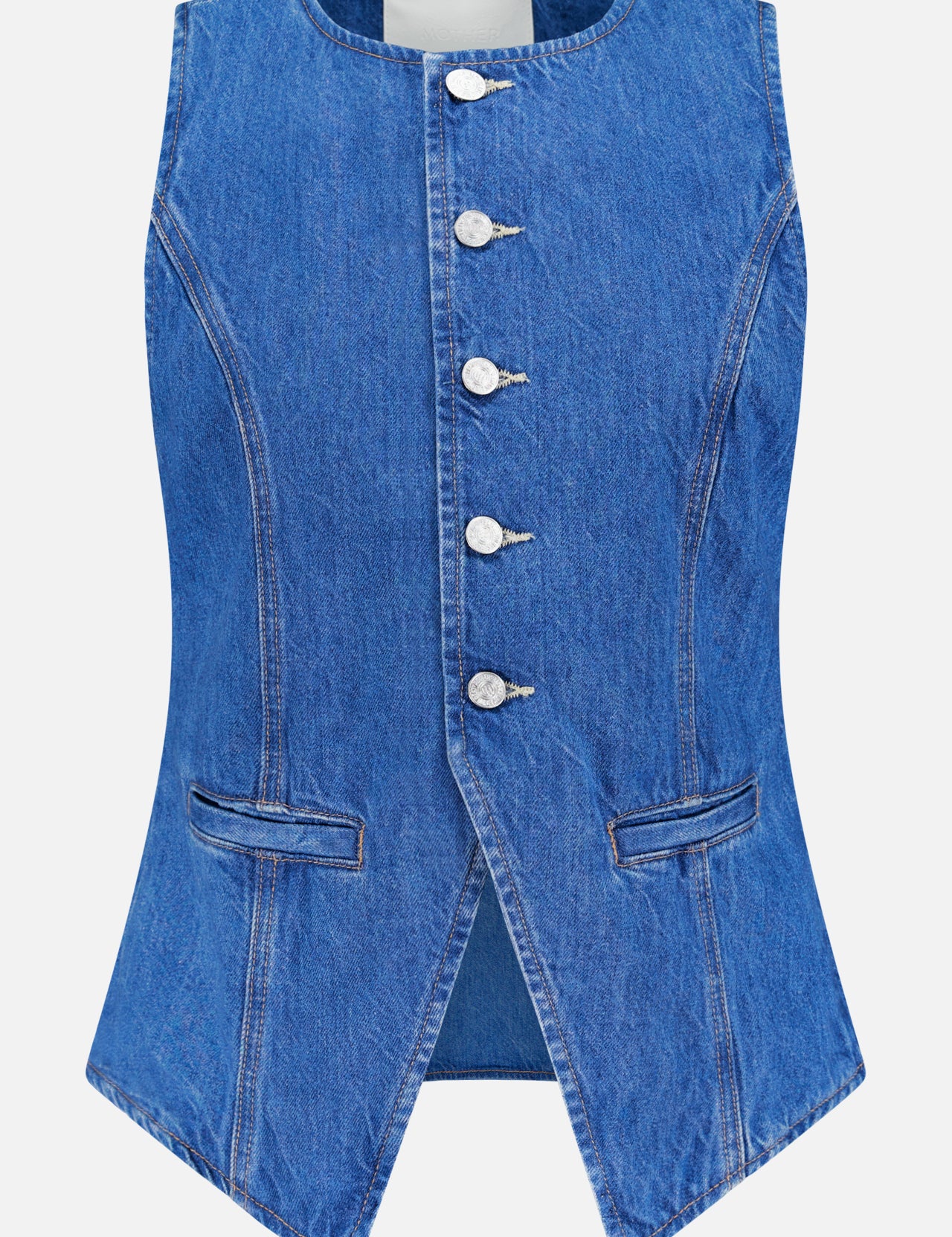 The Vested Interest Vest by MOTHER is a sleeveless blue denim top with a crew neck, five silver button-front closure, two small front pockets, subtle waist tapering, and a pointed open hem for added style.