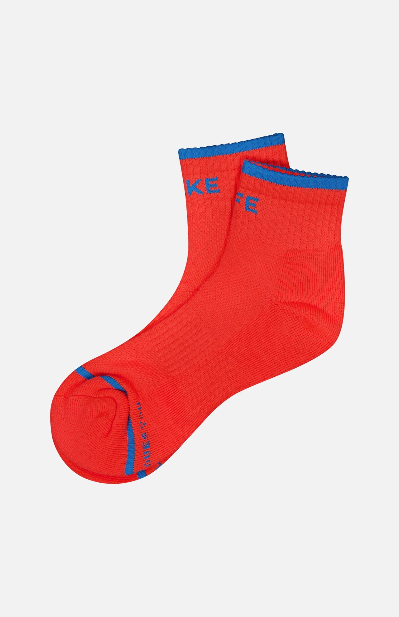 A pair of MOTHER Baby Steps Ankle Socks in bright red with blue accents on the toe, heel, and cuff, featuring bold blue text near the toe and ankle, shown against a plain white background.