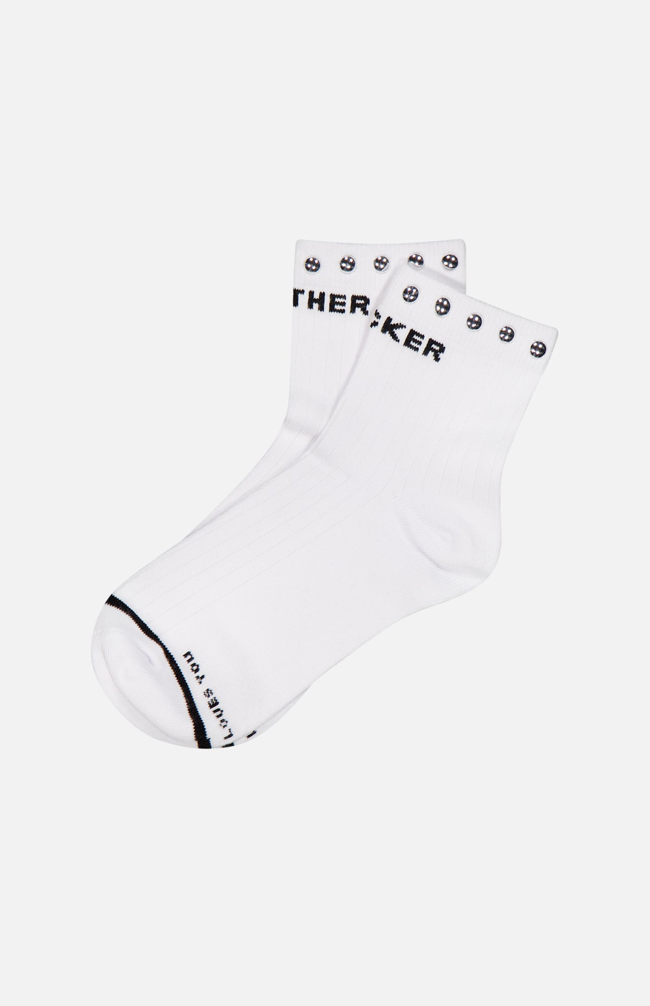 The Baby Steps Ankle Socks with Studs by MOTHER are white cotton-blend ankle socks featuring black text and smiley faces along the cuff. Additional black text decorates the toe area, adding a playful touch to these statement socks. They are shown laid flat on a white background.