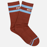 A pair of MOTHER Baby Steps Stripe Socks in brown with light blue stripes near the top. These unisex socks feature white text that partially reads “FUC” on one and “MOT” on the other.