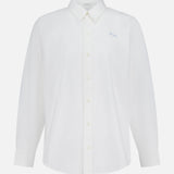The Bestie Button-front Shirt by MOTHER is a long-sleeve, 100% cotton white shirt with a collar and light blue embroidery on the left chest, shown against a white background.