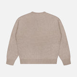 Back view of The Biggie Pegasus Jumper Sweater by MOTHER, shown in a plain, light beige shade and laid flat on a white background. This oversized crew neck sweater features ribbed cuffs, hem, and neckline, with no visible patterns or designs.