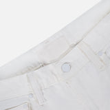 Close-up of the upper part of The Bookie Skimp Pant in Picket Fence by MOTHER, showing the waistband, belt loops, button, front pockets, and a blank white label on these classic mid-rise white denim jeans.