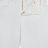 The Bookie Skimp Pant in Picket Fence by MOTHER is a pair of white mid-rise denim jeans with an open waistband, zipper, and button fly, shown laid flat against a white background.
