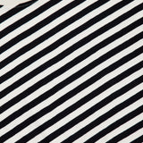A close-up view of The Boxy Goodie Goodie T-shirt by MOTHER, featuring black and white horizontal stripes, with the crew neck collar and part of the neck label visible at the top left corner.
