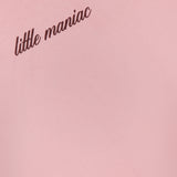 A close-up of MOTHER's The Boxy Goodie Goodie T-shirt in light pink, featuring "little maniac" in cursive brown text on the upper left side.