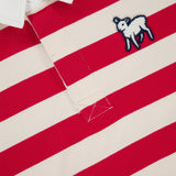 A close-up of The Boxy Rugby Match Shirt by MOTHER—a red and white striped, oversized rugby shirt with a small embroidered lamb patch on the chest and the MOTHER label inside the collar.