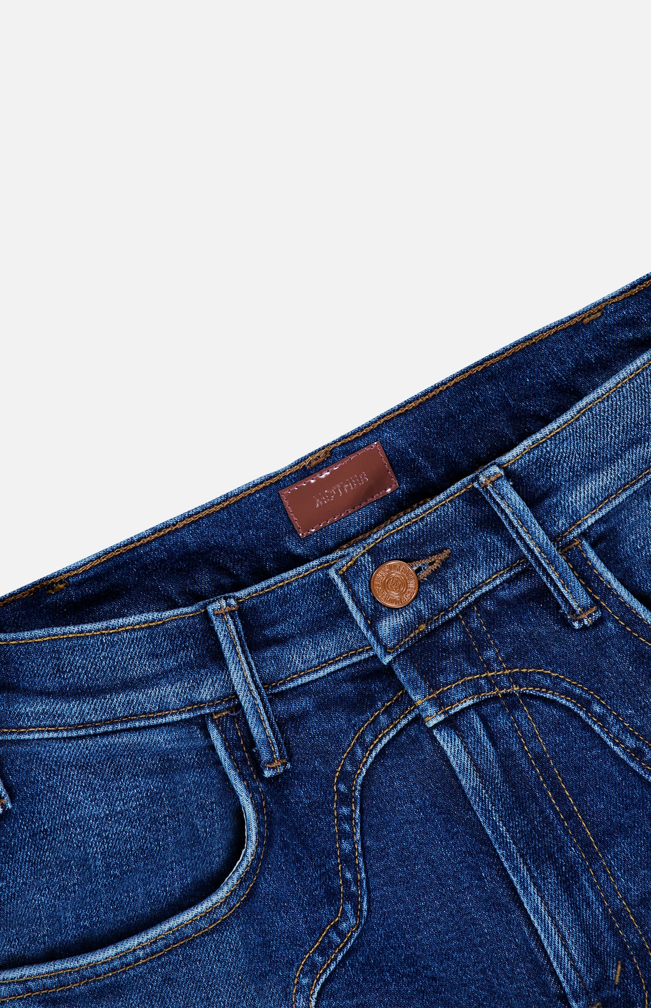 Close-up of the waistband and upper part of The Buckle Bunny Hustler Jean in Cosmic Cowgirl by MOTHER, featuring a brown button, belt loops, front pockets, and a leather patch on the inside of the waistband.