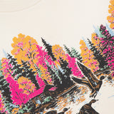 The Camper Lake Scene Sweatshirt by MOTHER features a lakeside cabin with autumn trees in pink, yellow, and orange. Three ducks fly over the water on this colorful cotton crew neck, with "MOTHER" partly visible at the neckline.