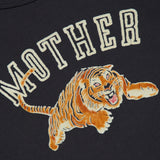 A dark 100% cotton sweatshirt called the Concert Tiger Sweatshirt by MOTHER, featuring the brand name in large letters above an illustrated orange and black tiger mid-leap with its mouth open and front paw extended.