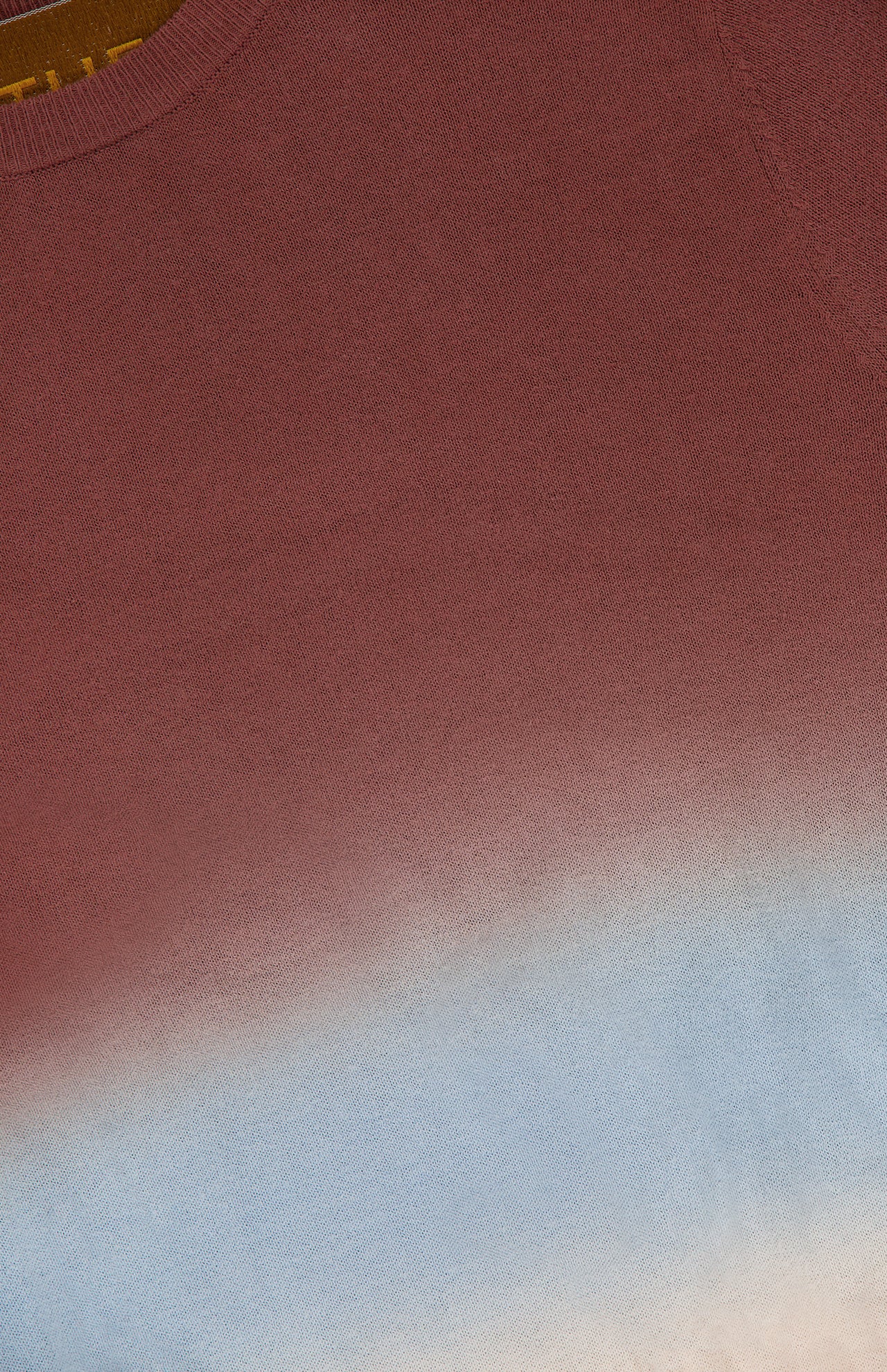 A close-up of the MOTHER Crew Neck Ombre Jumper Sweatshirt shows its cotton fabric with a gradient from reddish-brown at the top to light blue and off-white at the bottom, and a visible crew neckline in the upper left corner.