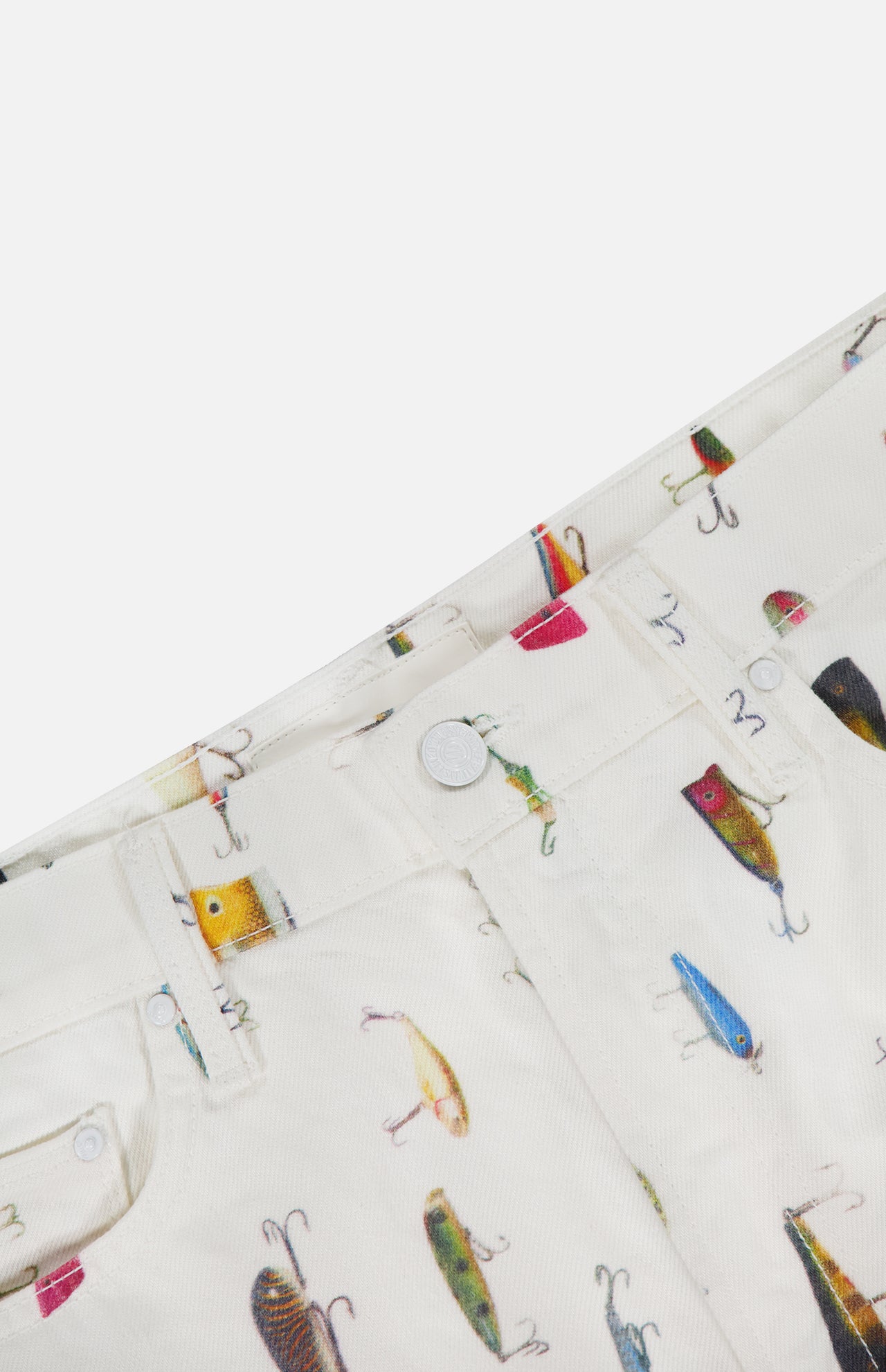 Close-up of the MOTHER Dodge Ball Fishing Lure Shorts, high-waisted with a vivid fishing lure print on cream fabric. Features include a visible waistband, front pocket, belt loop, and button closure.