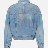 The Rhinestone Fringe Fly Away Jacket by MOTHER is pictured in light blue denim, showcased from the back. It features silver beaded and rhinestone fringe with decorative studs adorning the shoulders and upper back. With its long sleeves and buttoned cuffs, this party-ready jacket adds a standout touch to your wardrobe.