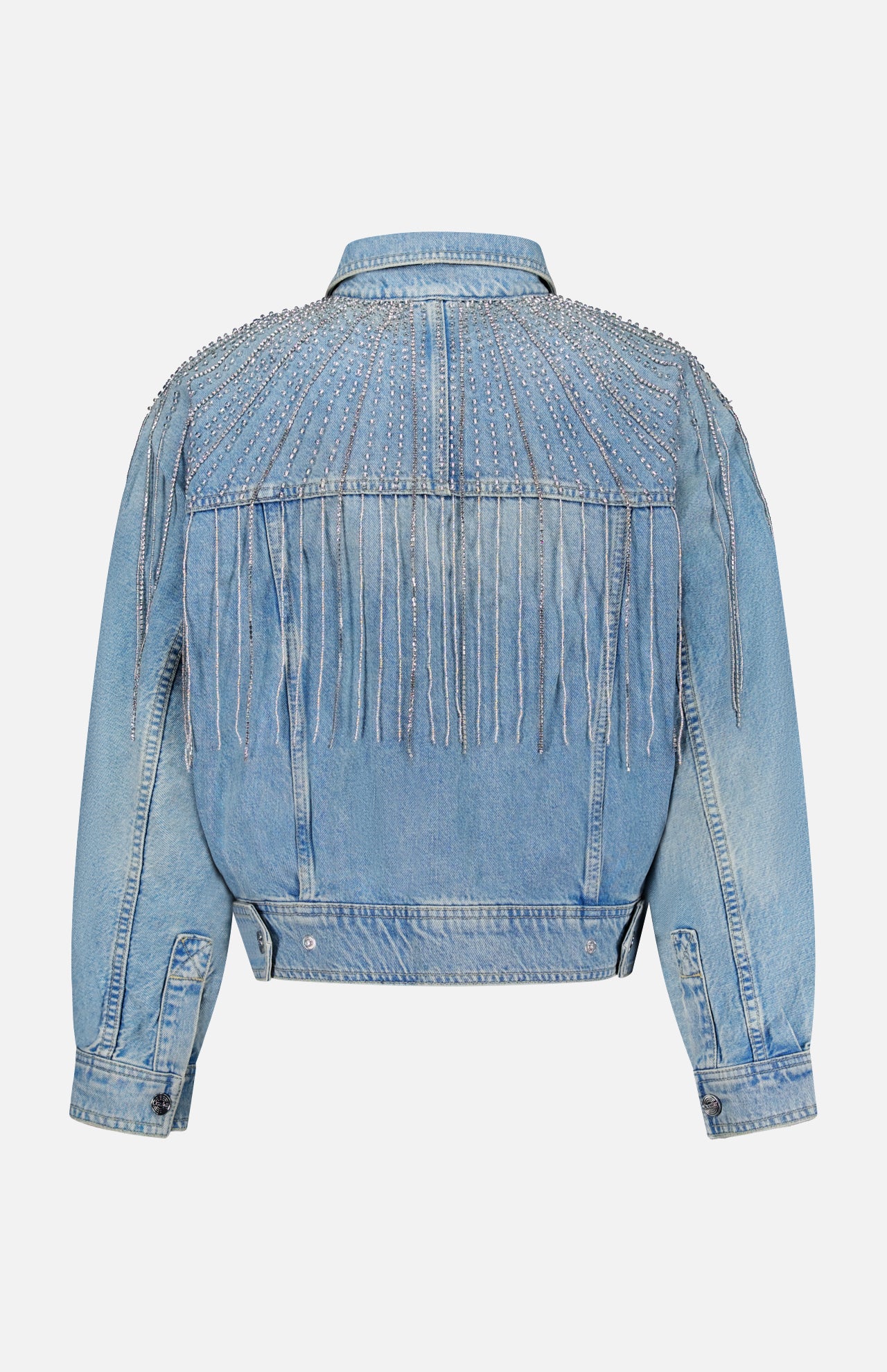 The Rhinestone Fringe Fly Away Jacket by MOTHER is pictured in light blue denim, showcased from the back. It features silver beaded and rhinestone fringe with decorative studs adorning the shoulders and upper back. With its long sleeves and buttoned cuffs, this party-ready jacket adds a standout touch to your wardrobe.