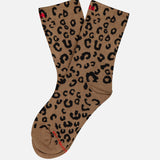The Half-Step Cheetah Socks by MOTHER, featuring a black cheetah print on brown, are laid flat on a white background.