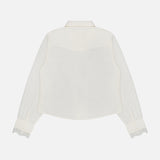 The Headup Honey Shirt by MOTHER is a white long-sleeve blouse, featuring lace trim on the cuffs and shown from the back against a plain white background. Designed with a collar and a slightly curved hem, it offers a subtle western-inspired silhouette.