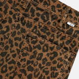 Close-up of The Hustler Flood Pant in Leap Year by MOTHER, featuring brown stretch corduroy with a black leopard print, front pocket, belt loops, and a small white label near the waistband.