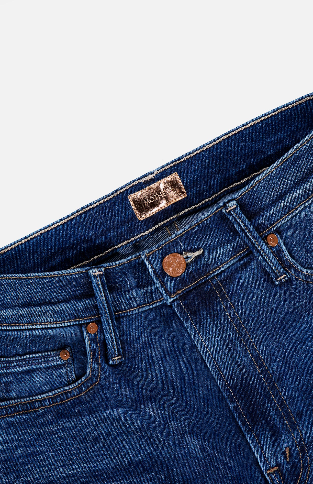Close-up of the waistband and pockets of The Insider Skimp Jean in Taking Chances by MOTHER, showcasing blue stretch denim, a copper button, belt loops, and a brown interior label for classic vintage style.